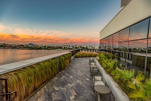 a building with a patio with a view of the water at Mercure Itajai Navegantes in Itajaí
