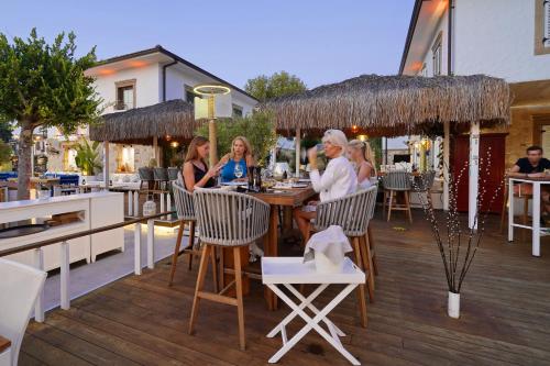 a group of people sitting at a table on a deck at Carpe Diem Boutique Hotel - Adults Only in Side