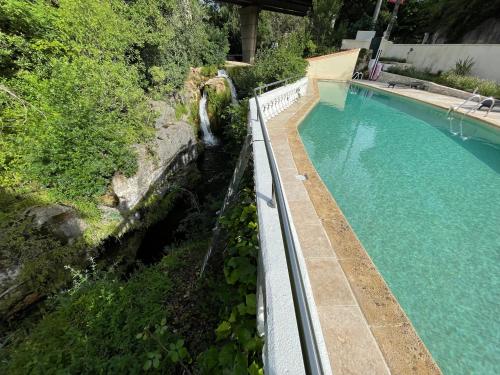 an overhead view of a swimming pool next to a waterfall at MOULIN DE L'OULETTE in Soubès