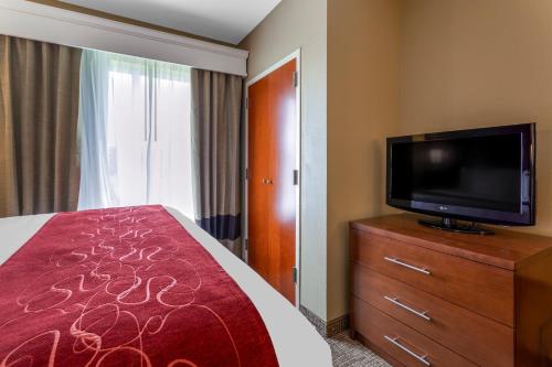 a hotel room with a bed and a flat screen tv at Comfort Suites Knoxville North in Knoxville