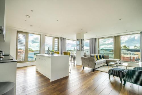a living room with a kitchen and a living room with windows at Skyview Retreat @ Ryedale House in York