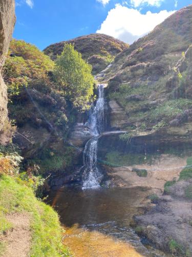 a waterfall on the side of a mountain next to a river at The Old Schoolhouse, Kinross in Kinross