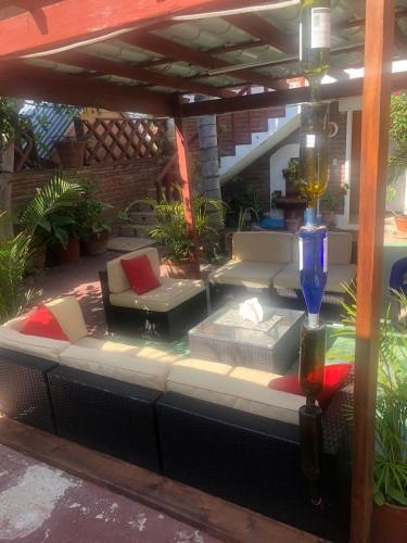 an outdoor patio with a couch and a table at Casa Jardin Rosarito in Rosarito