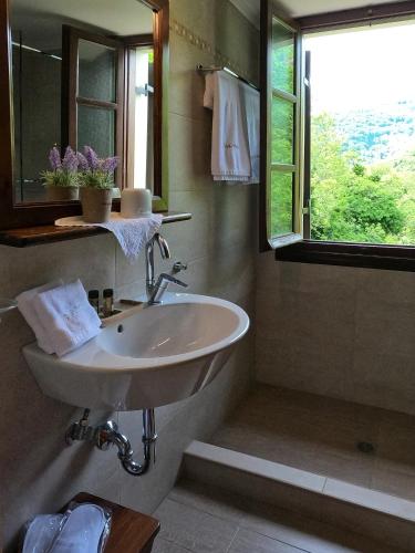 a bathroom with a sink and a window at Amalthia Traditional Guesthouse in Tsagarada