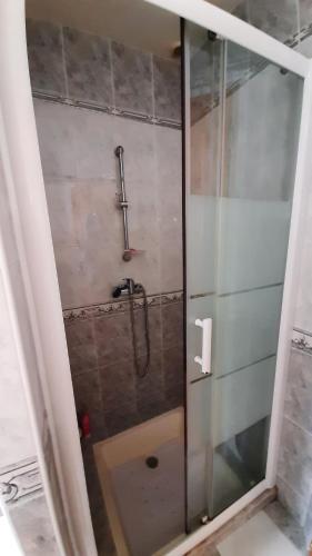 une douche avec une porte vitrée dans une salle de bain dans l'établissement Maison de ville au calme, de plain pied, 2 chambres, à Saint-Jean-de-Monts