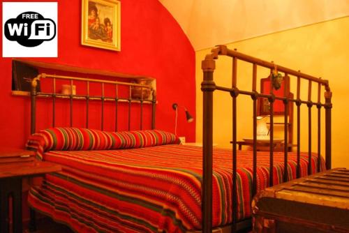 a bedroom with a bed with a red wall at Cueva La Ermita in Guadix