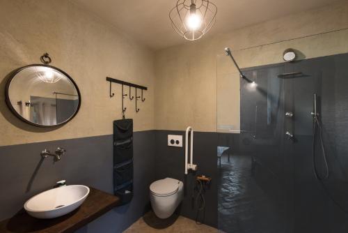 a bathroom with a sink toilet and a mirror at BED&BEER BIRRIFICIO LA GRAMIGNA in Perugia