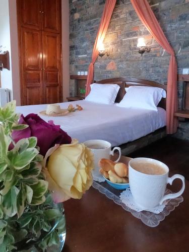 a bedroom with a bed and two cups of coffee at Amalthia Traditional Guesthouse in Tsagarada