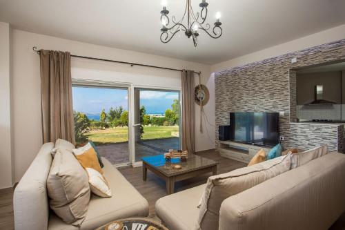 a living room with a couch and a tv at AGGELOS GARDEN VIEW in Faliraki