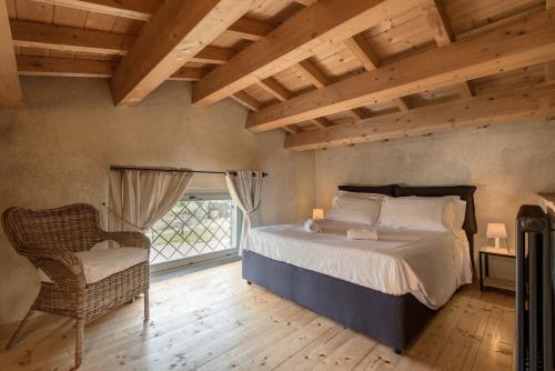 ein Schlafzimmer mit einem Bett, einem Stuhl und einem Fenster in der Unterkunft BED&BEER BIRRIFICIO LA GRAMIGNA in Perugia
