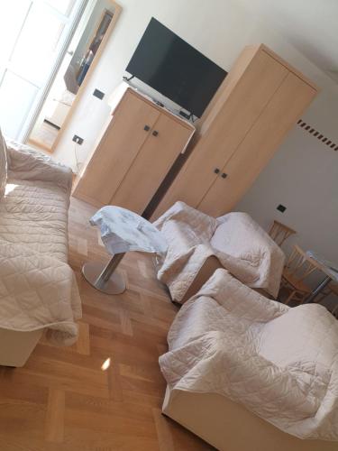a bedroom with two beds and a flat screen tv at Šmartno Apartmaji Goran in Kojsko