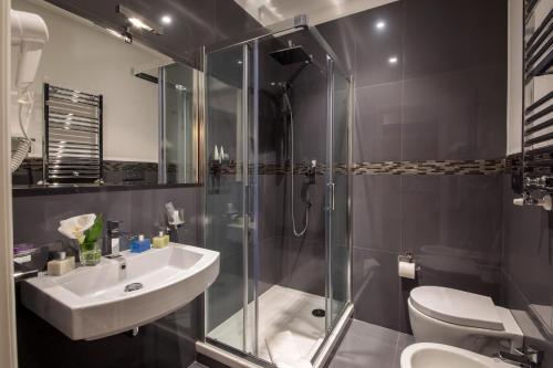 bagno con doccia, lavandino e servizi igienici di Tridente Suites a Roma