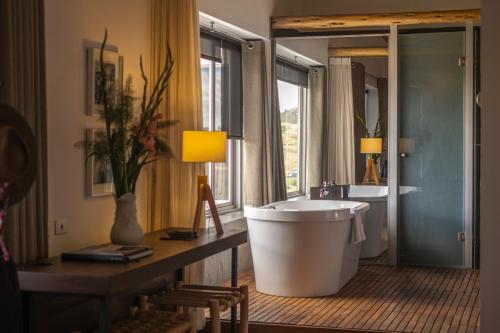 a bathroom with a large tub and a sink at Titilaka by Andean in Tililaca