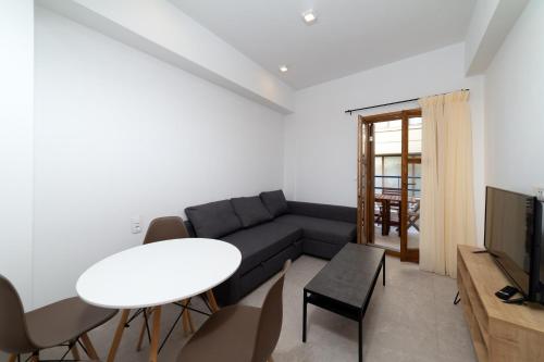 una sala de estar con un sofá y una mesa en Quince city center, en Heraclión