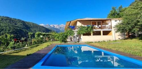 a house with a swimming pool in front of a house at Guesthouse Dolra Svaneti in Becho