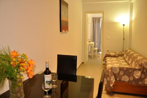 a living room with a couch and a table with a bottle of wine at Dina's Paradise in Agios Gordios