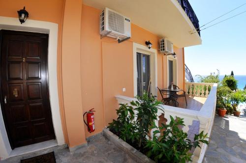 a house with a door and a balcony with a table at Dina's Paradise in Agios Gordios