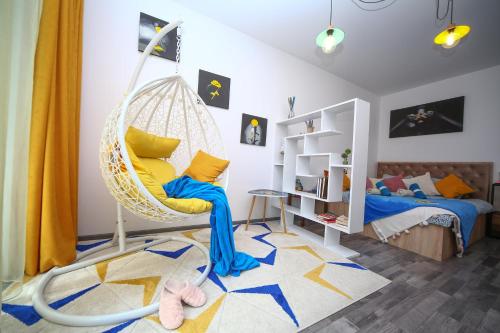 a room with a swinging chair and a bed at B&M Apartment in Braşov