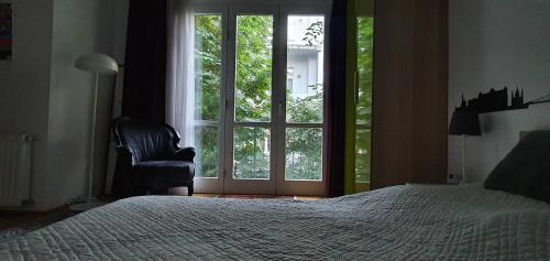 ein Schlafzimmer mit einem Bett, einem Fenster und einem Stuhl in der Unterkunft Mintage Apartment /Former Mirage Apartment in Budapest