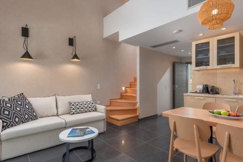 a living room and kitchen with a couch and a table at ALPE LUXURY ACCOMMODATION Penelope Collection in Olympiada
