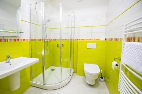 a bathroom with a shower and a toilet and a sink at Hotel Berounka in Hřebečníky