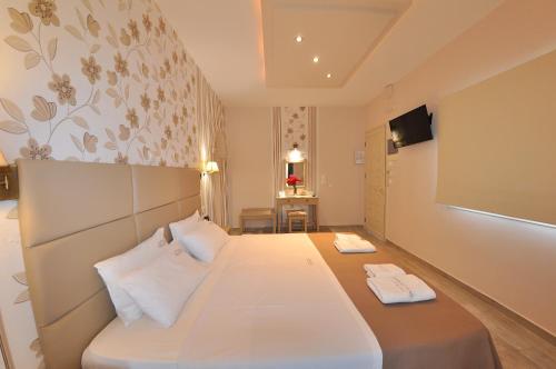 a hotel room with a bed with two white pillows at Dina's Paradise in Agios Gordios