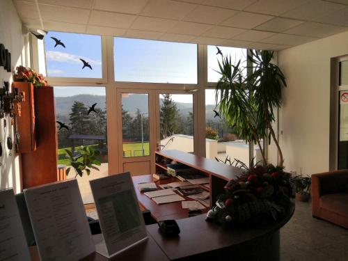 a office with a desk with birds flying in the air at Hotel Berounka in Hřebečníky