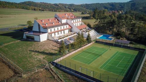 an aerial view of a house with a tennis court at Hotel Berounka in Hřebečníky