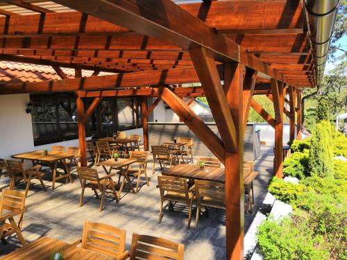 an outdoor patio with wooden tables and chairs at Hotel Berounka in Hřebečníky