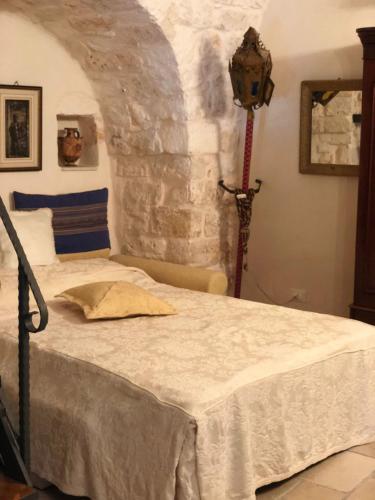 a bedroom with a bed with a stone wall at Casa Federico in Ostuni