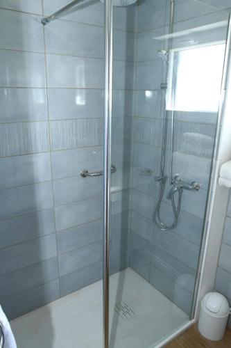 a shower with a glass door in a bathroom at Hotel Royal Albion in Mesnil-Val-Plage