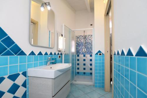 カステルサルドにあるResidence Auroraの青と白のバスルーム(シンク、鏡付)