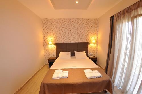 a bedroom with a bed with two towels on it at Dina's Paradise in Agios Gordios
