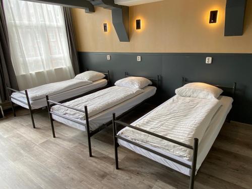 three beds are lined up in a room at Xplore Hostel Amsterdam in Amsterdam