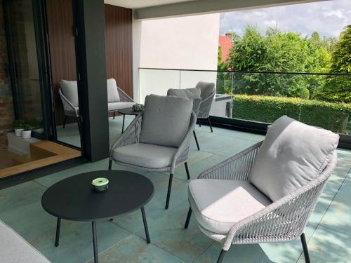 a living room with chairs and a table and windows at HÔTELYA - Lille Villeneuve d'Ascq in Villeneuve d'Ascq