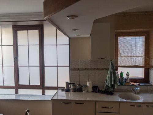 a kitchen with a sink and a large mirror at Central apartment with city view in Prizren