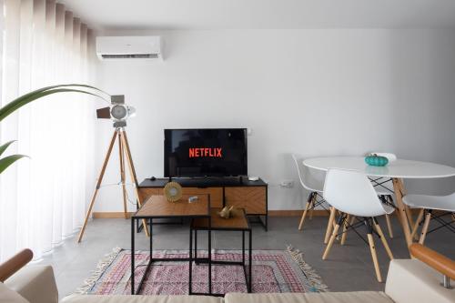 a living room with a tv and a table at Abraços dos Avós - Casas de aldeia in Viana do Castelo