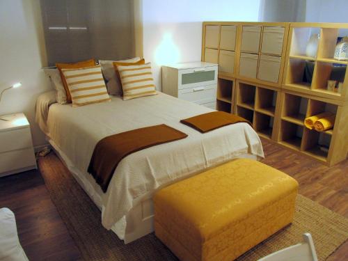 um quarto com uma cama grande e um repousa-pés amarelo em Go PT - Private challet with swimming pool and garden em Parede