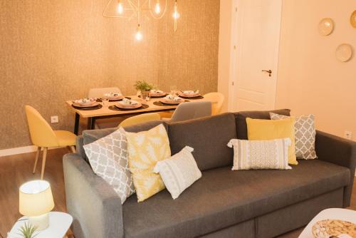 a living room with a gray couch and a table at Apartamento Circo Romano- con vistas al Circo Petfriendly in Merida