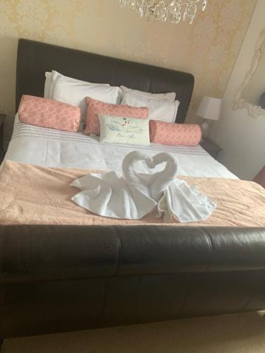 a bed with two heart shaped towels on it at the swan stoford in Salisbury