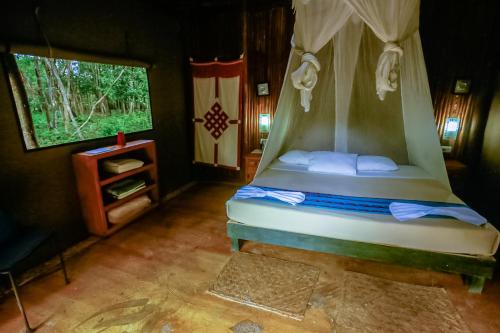 a bedroom with a bed and a television at Akumal Natura Glamping in Akumal