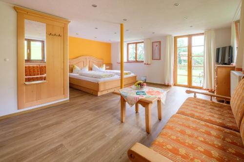 ein Wohnzimmer mit einem Bett und einem Tisch in der Unterkunft Gästehaus Schlegel in Gunzesried
