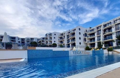 uma piscina em frente a alguns edifícios de apartamentos em Vega Village Ap A8 em Sveti Vlas