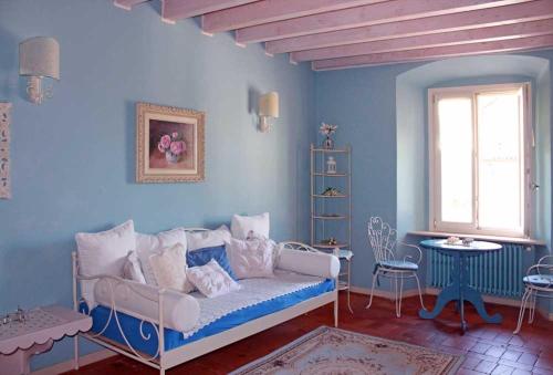 a blue room with a couch and a table and a window at Borgo alla Sorgente in Vallio Terme
