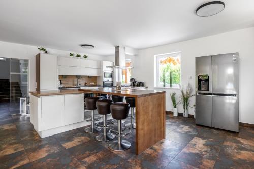 a kitchen with white cabinets and a wooden island with bar stools at 5-star Chalet Helen Deluxe in Kaprun with Air Condition in Kaprun