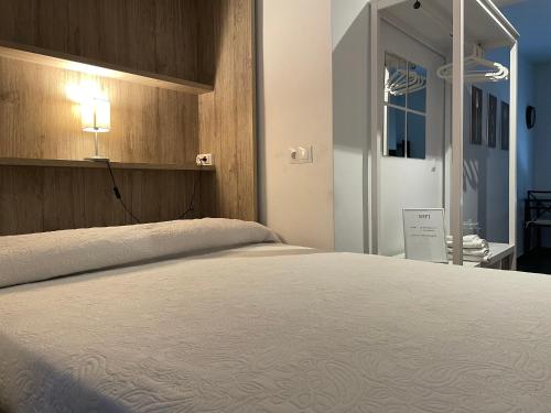 a bedroom with a large bed with a light on it at Loft Ciudad Jardín in Córdoba