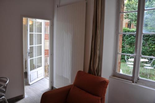 a living room with a chair and a window at location studio meublé avec jardin in Sorgues