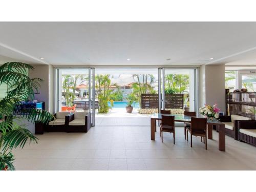 a living room with a couch and a table and chairs at HOTEL GranView Garden OKINAWA - Vacation STAY 44961v in Tomigusuku