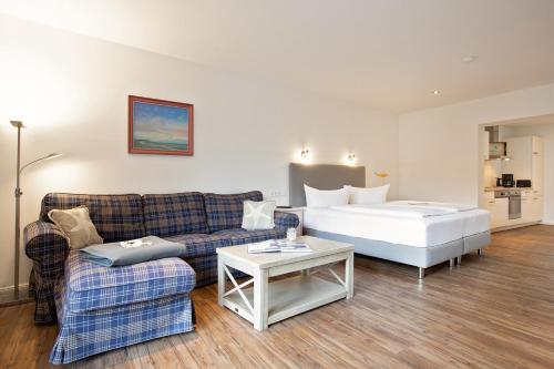 ein Wohnzimmer mit einem Sofa und einem Bett in der Unterkunft Appartements Hafen 31 in Wittdün