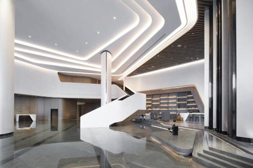 武漢市にあるCrowne Plaza Wuhan Optics Valley, an IHG Hotelのロビー付き建物内の螺旋階段